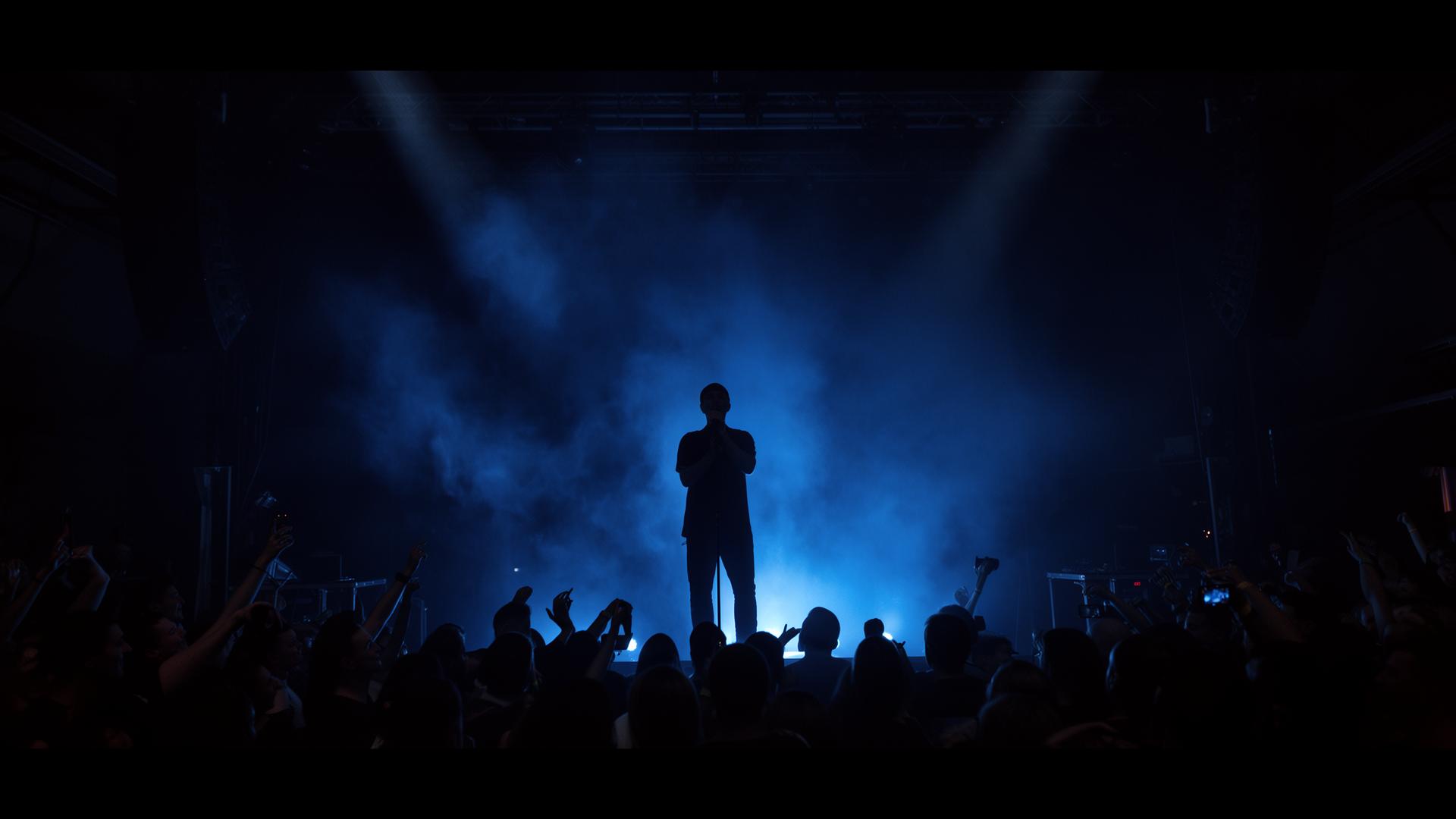 Performer silhouetted against blue stage lights